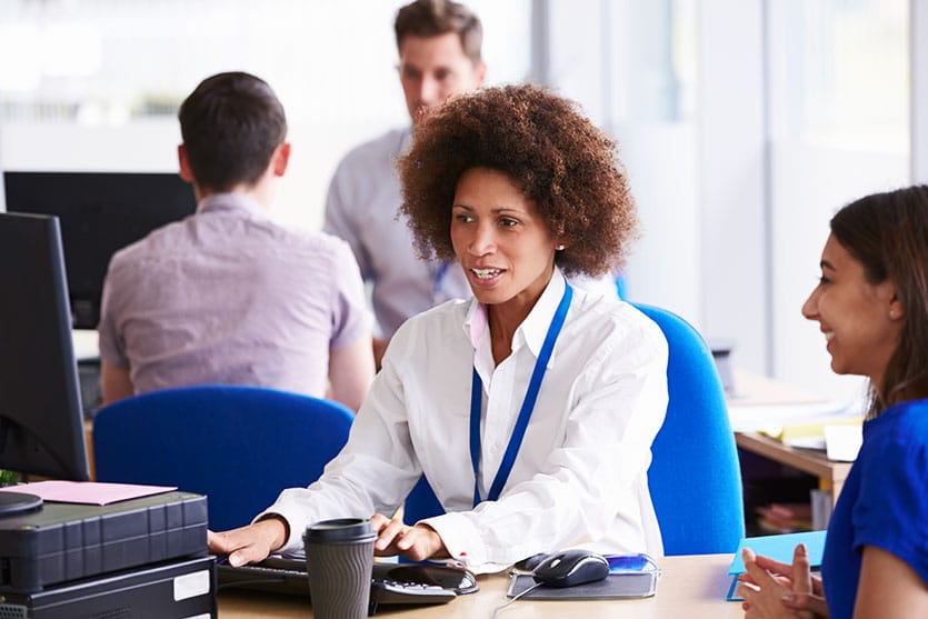 A happy worker at a foundation job with her hardworking, diverse team.