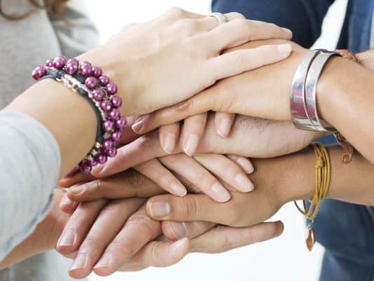 Four Nonprofit Staff Holding Hands
