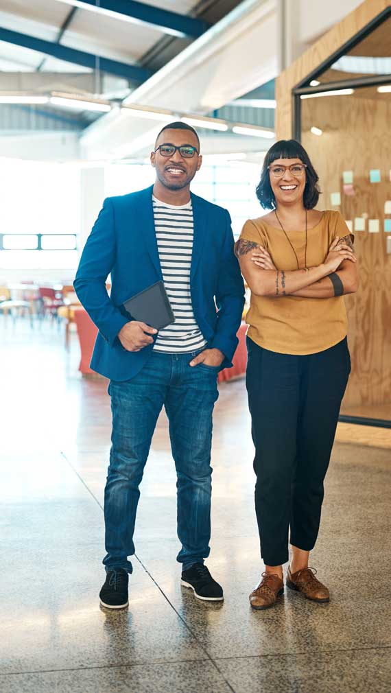 Image of two nonprofit workers standing in a office smiling