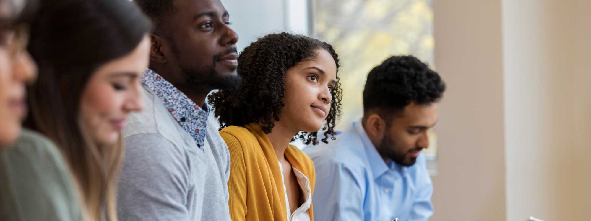 Nonprofit jobs - a group of five nonprofit job seekers can be seen sitting and waiting to interview.