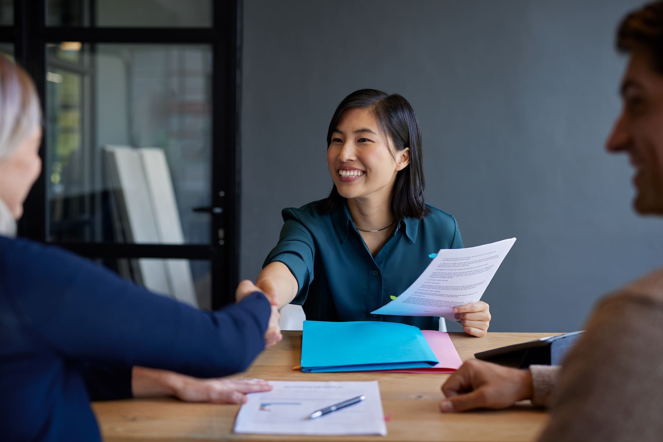 Foundation List Job Board Recruiter is seen shaking hands at an interview with a candidate smiling and a conference room