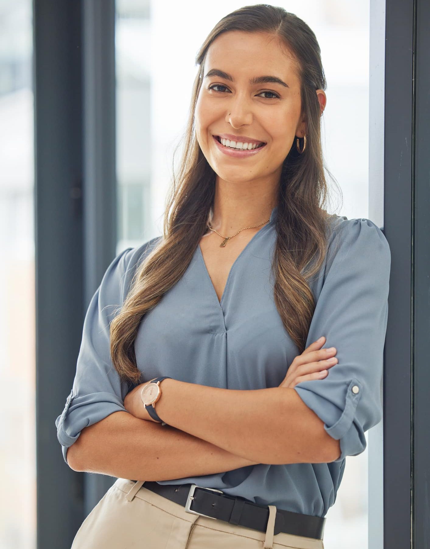 Nonprofit Job Candidate from Foundation List is seen standing with arms crossed and smiling after a job interview