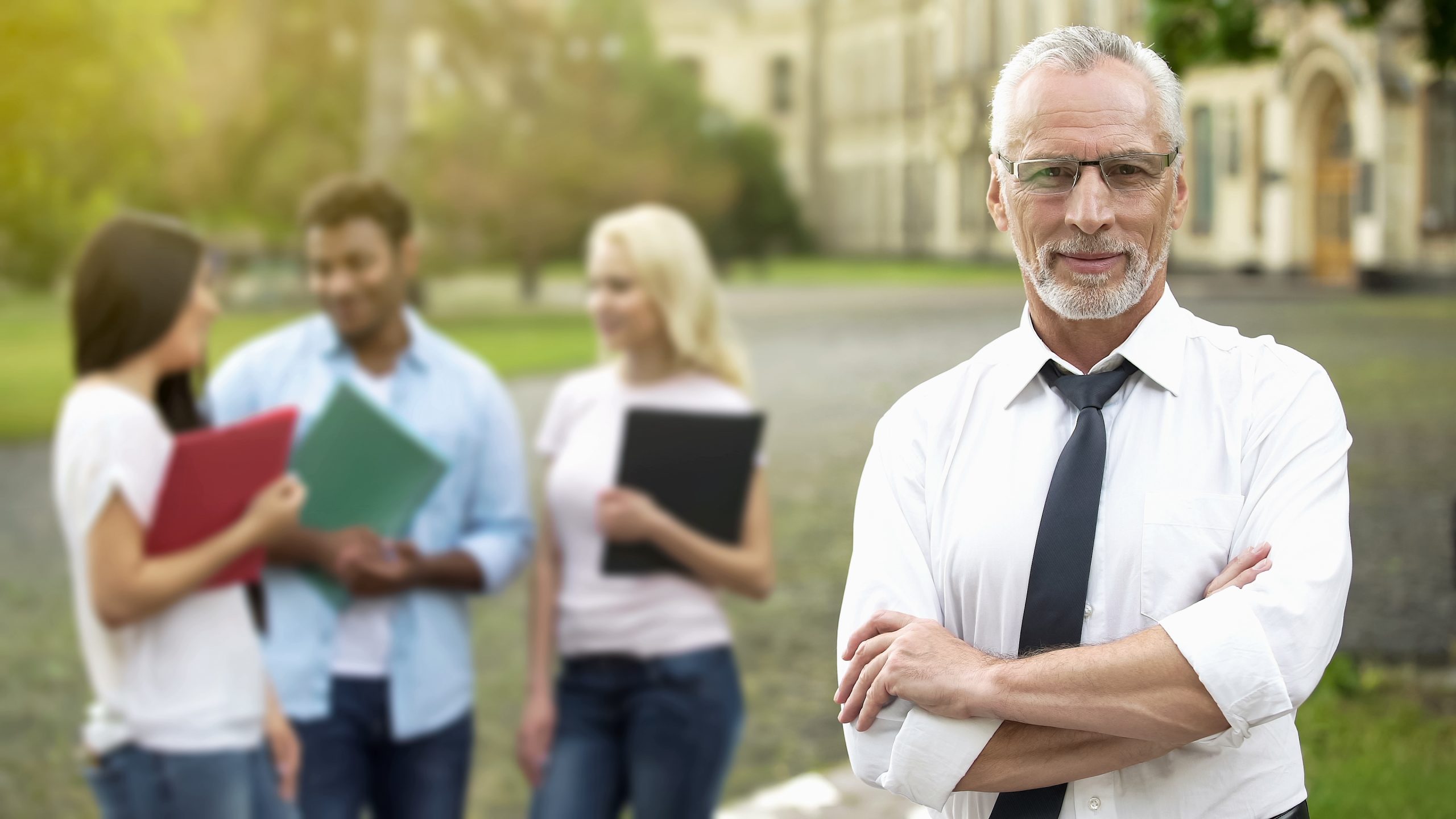 Higher education leader standing with arms crossed and smiling