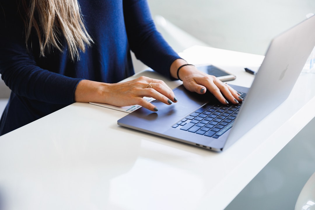 Professional writing a nonprofit cover letter at a laptop in an office