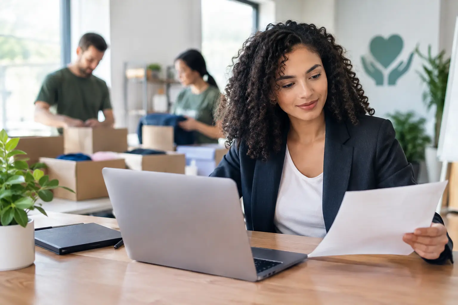 Professional reviewing an application document beside a laptop